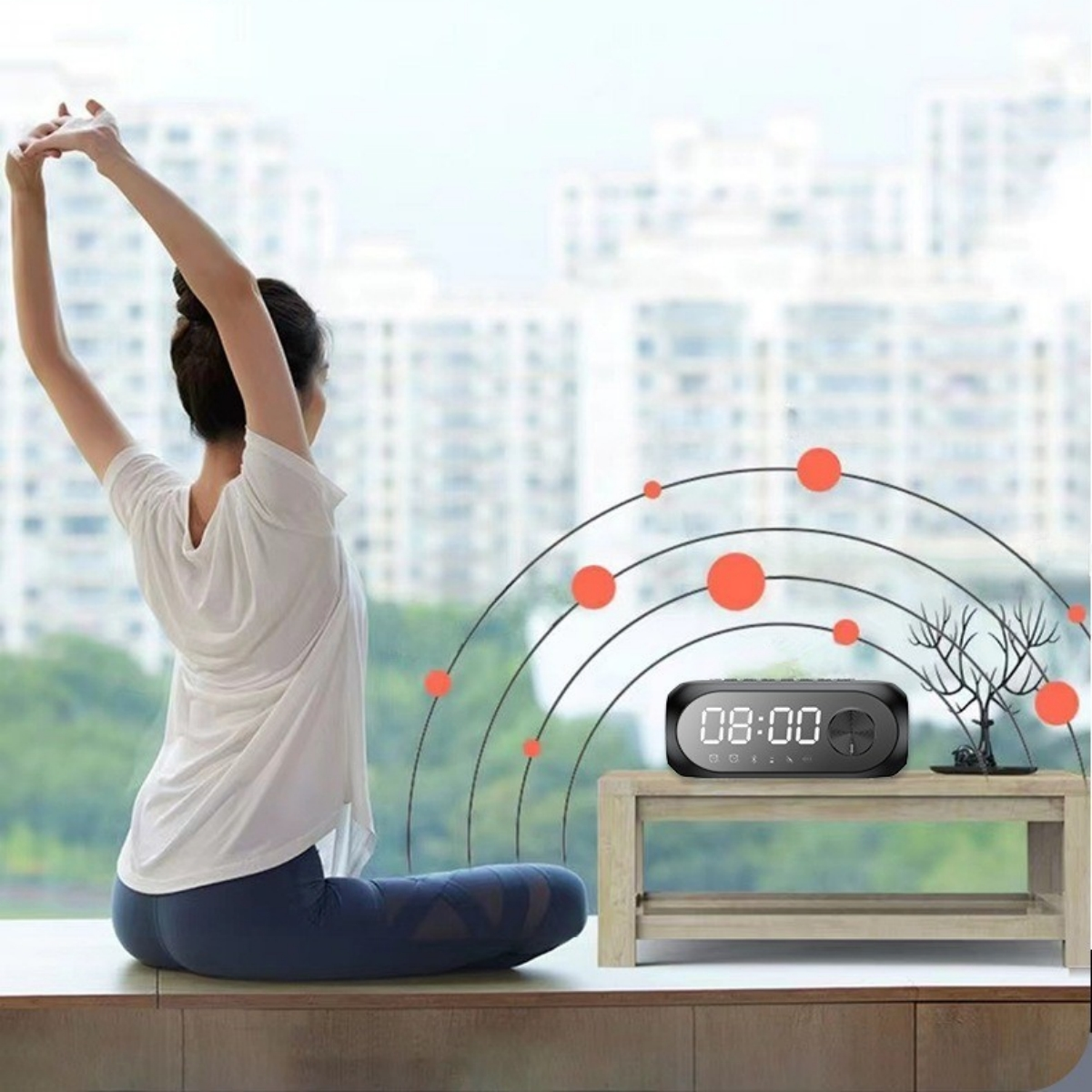 Frau in Yoga-Pose. Uhr und kleiner Baum auf einem Tisch am Fenster. Rote Kreise.