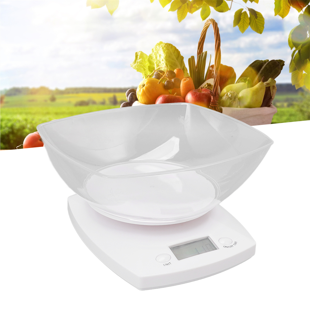 Eine weiße digitale Küchenwaage mit klarer quadratischer Schüssel. Obst und Gemüse in einem Korb im Hintergrund.