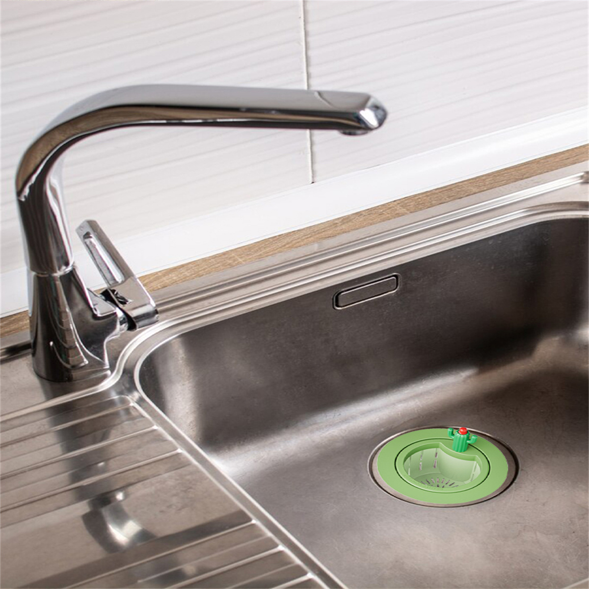 Ein Küchenspülbecken mit Wasserhahn und einem grünen Müllentsorgungssystem.