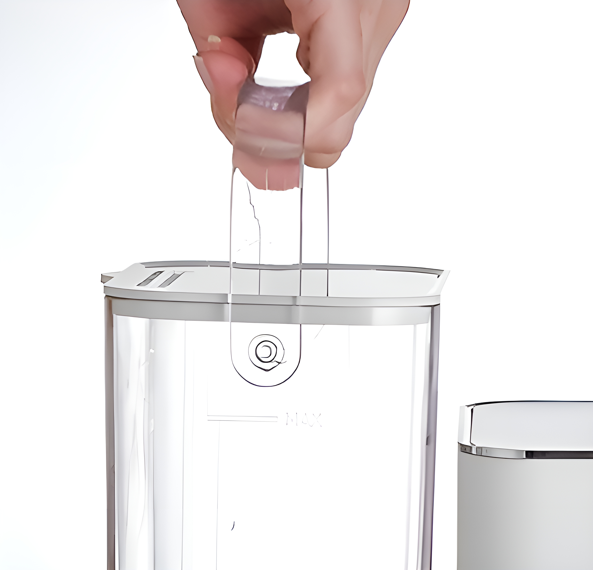 Eine Hand hält einen durchsichtigen Kunststoffgriff über einem transparenten Behälter mit weißem Deckel.