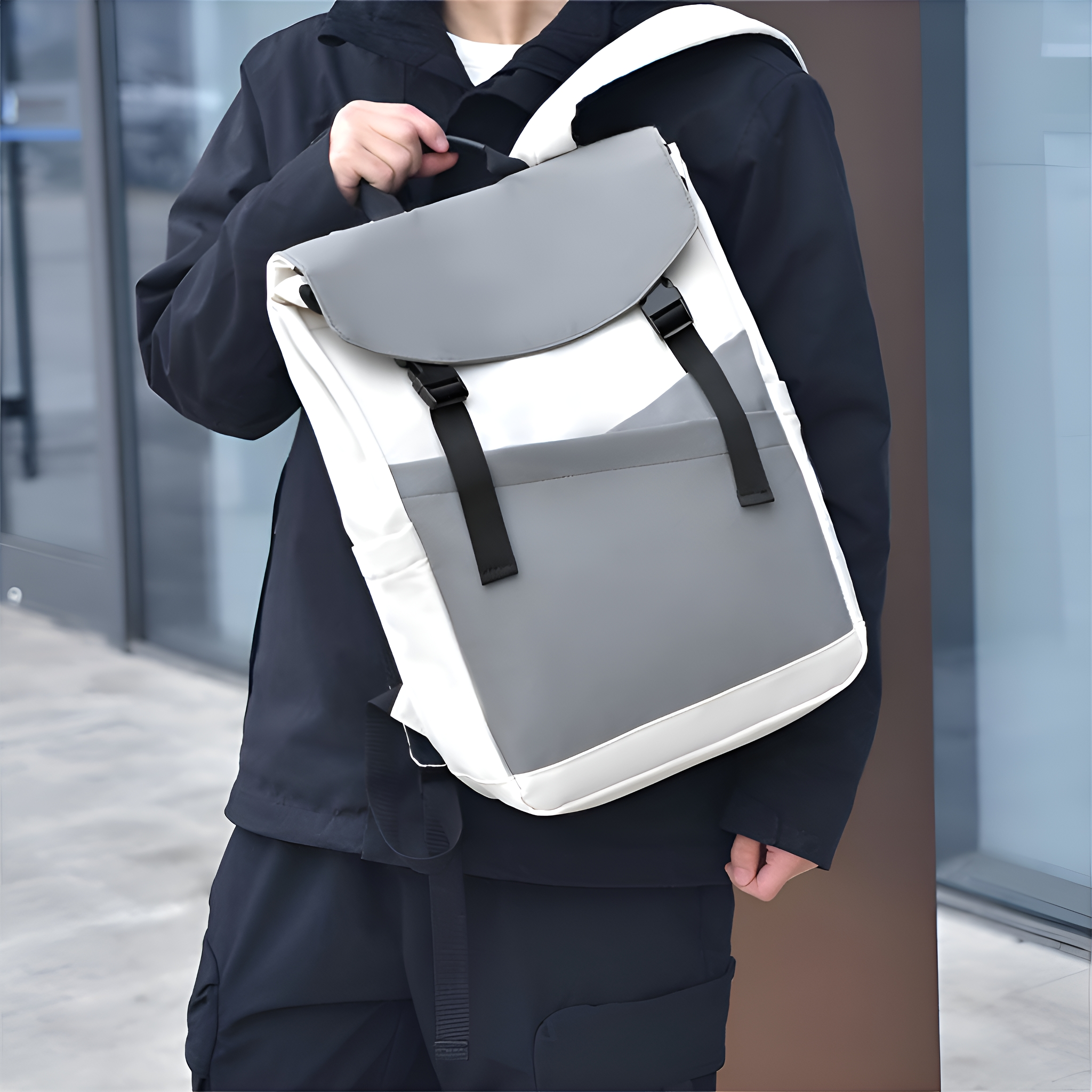 Eine Person mit einem Rucksack, weißes und graues Farbschema, mit schwarzen Trägern und dunkler Jacke.