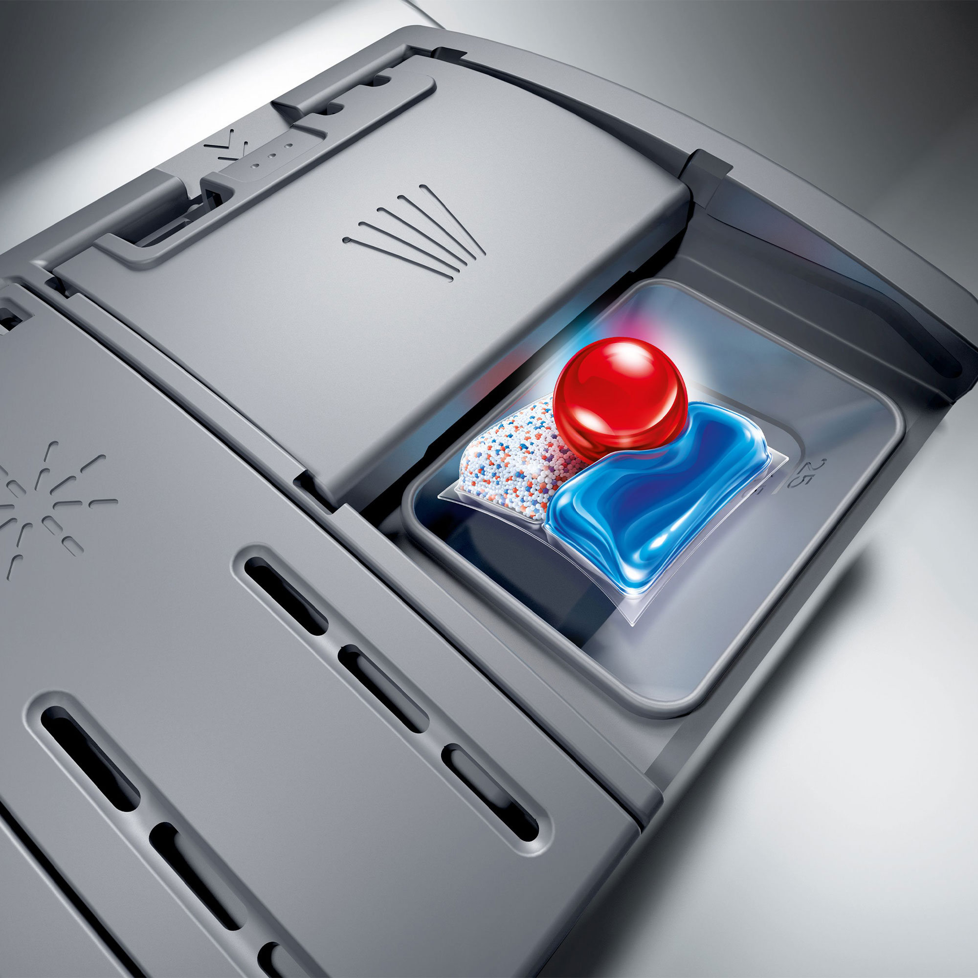 Compartiment à détergent pour lave-vaisselle avec trois pods différents: rouge, bleu et blanc.