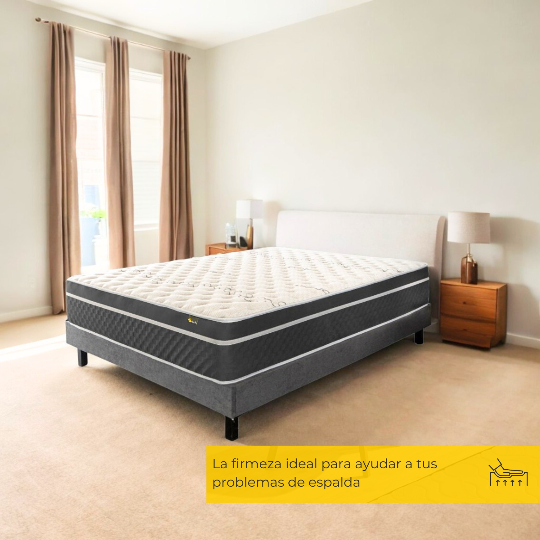 Una cama con cabecero blanco, base gris y un colchón con parte superior estampada, en una habitación con ventanas.