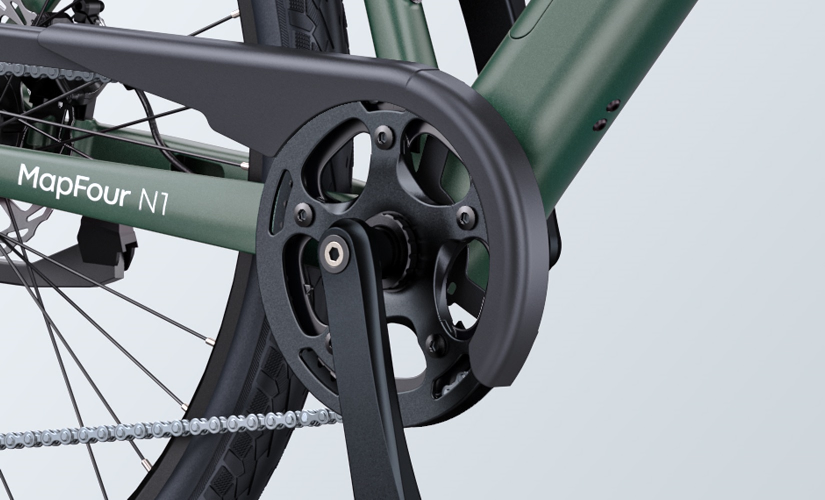 Nahaufnahme eines grünen Fahrrad-Kettenschutzes, einer Kurbel und Pedale. Der Rahmen ist sichtbar.