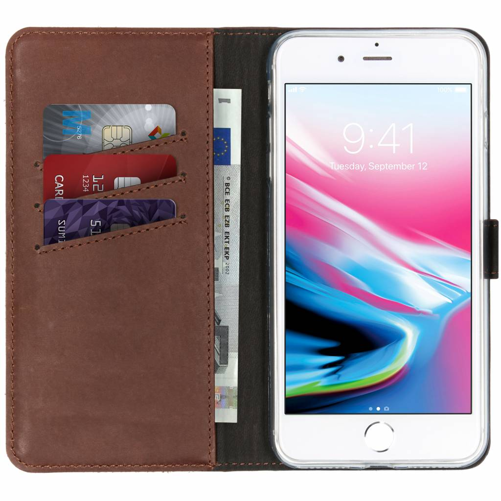 Bruine leren telefoonhoes open, met telefoon, creditcards en geld zichtbaar.