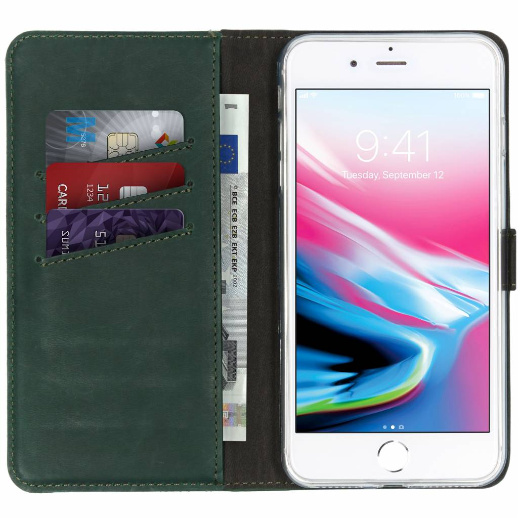 Telefoon in een groene portemonnee-hoes, met creditcards en geld erin. De telefoon toont tijd.