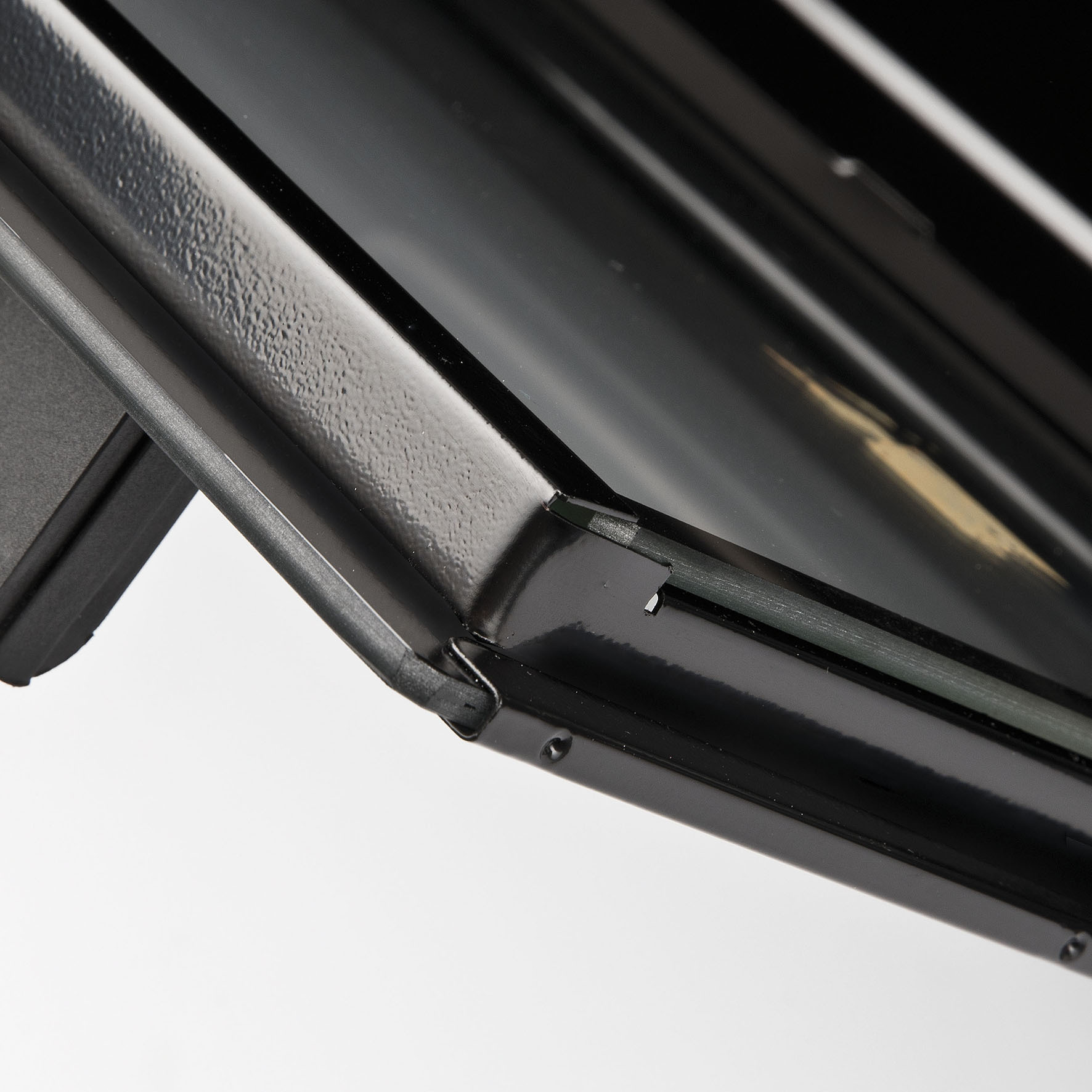 Primo piano di una porta del forno nera, che mostra il vetro e il telaio metallico. Sfondo bianco.