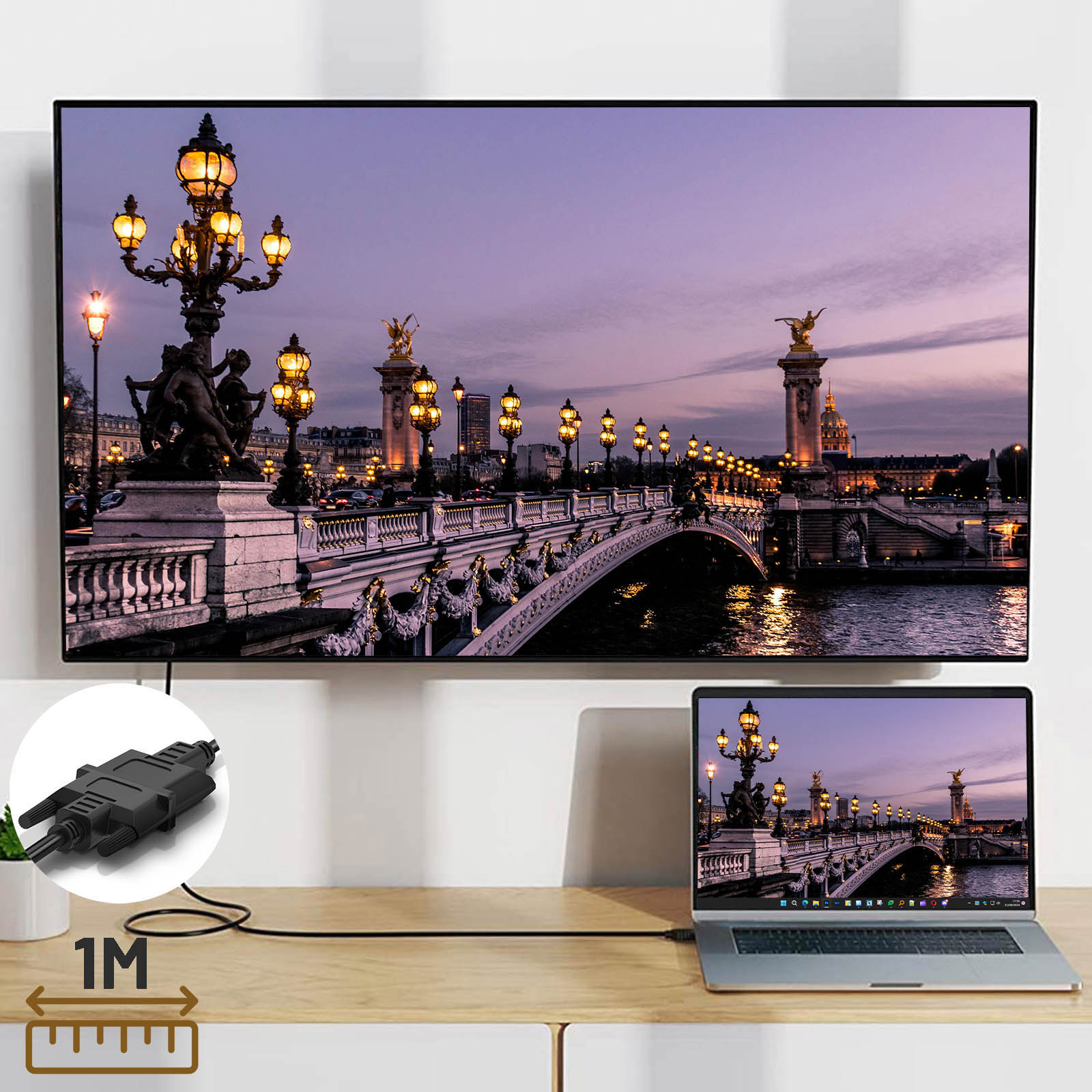 Schermo grande che mostra un ponte con luci. Un laptop e un cavo HDMI sono di fronte allo schermo.