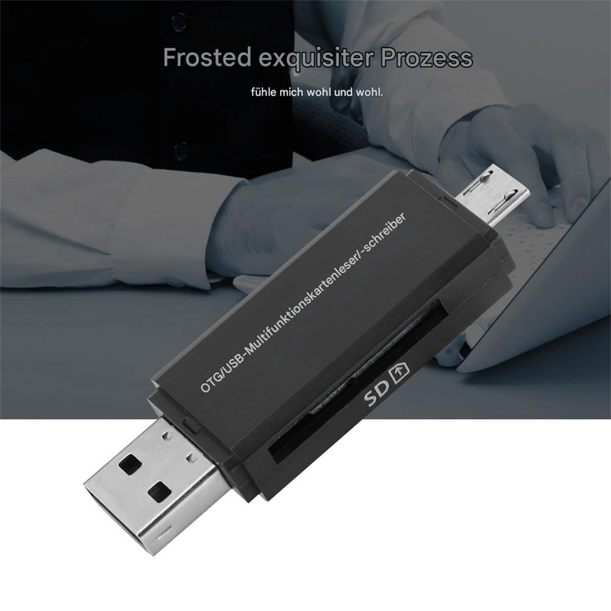 Schwarzer Kartenleser. USB- und SD-Steckplätze sind sichtbar. Im Hintergrund arbeitet eine Person an einem Laptop.