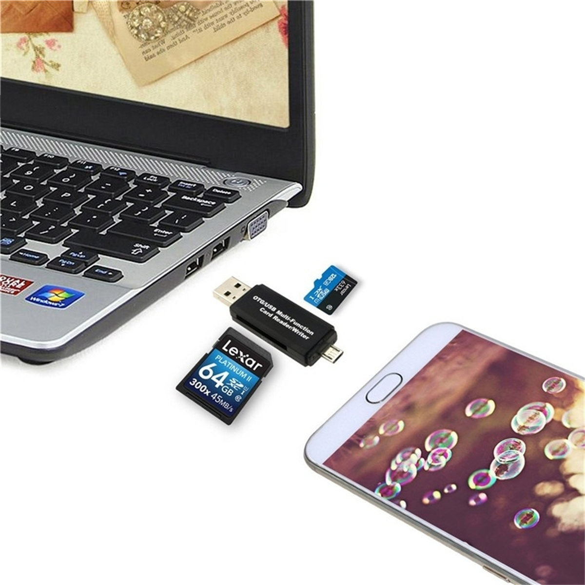 Ein Laptop, ein Telefon und Speicherkarten liegen auf einer weißen Oberfläche. Es gibt einen Kartenleser.