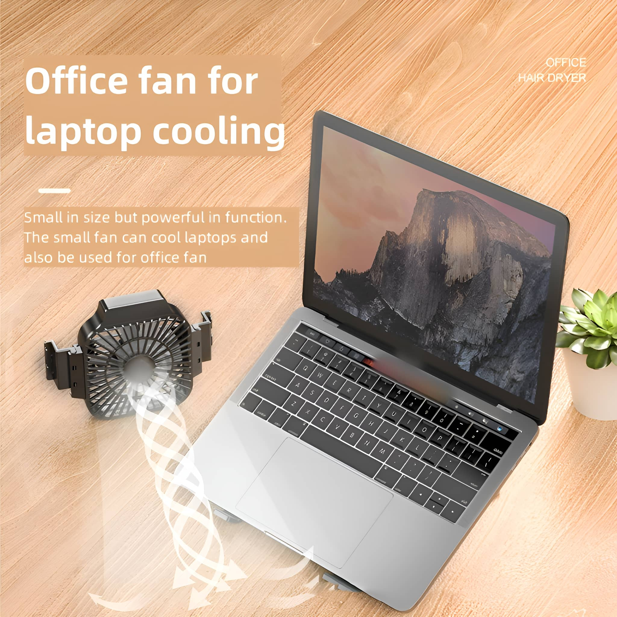 Laptop-Lüfter auf einem Schreibtisch. Ein Laptop ist geöffnet. Der Lüfter bläst Luft in Richtung Laptop. Daneben eine Pflanze.