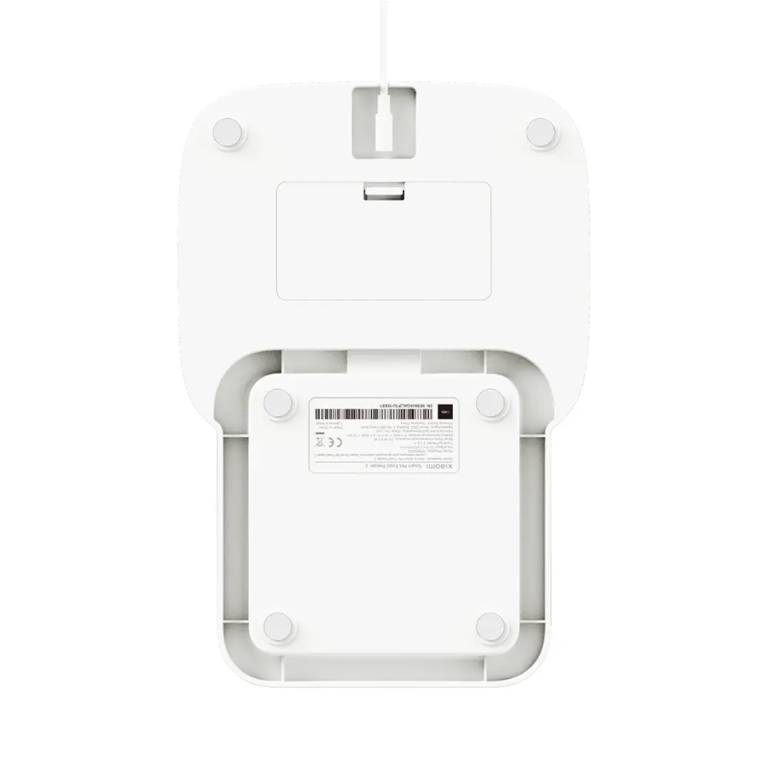 Spód białego urządzenia elektronicznego z prostokątną sekcją i kilkoma okrągłymi nóżkami.