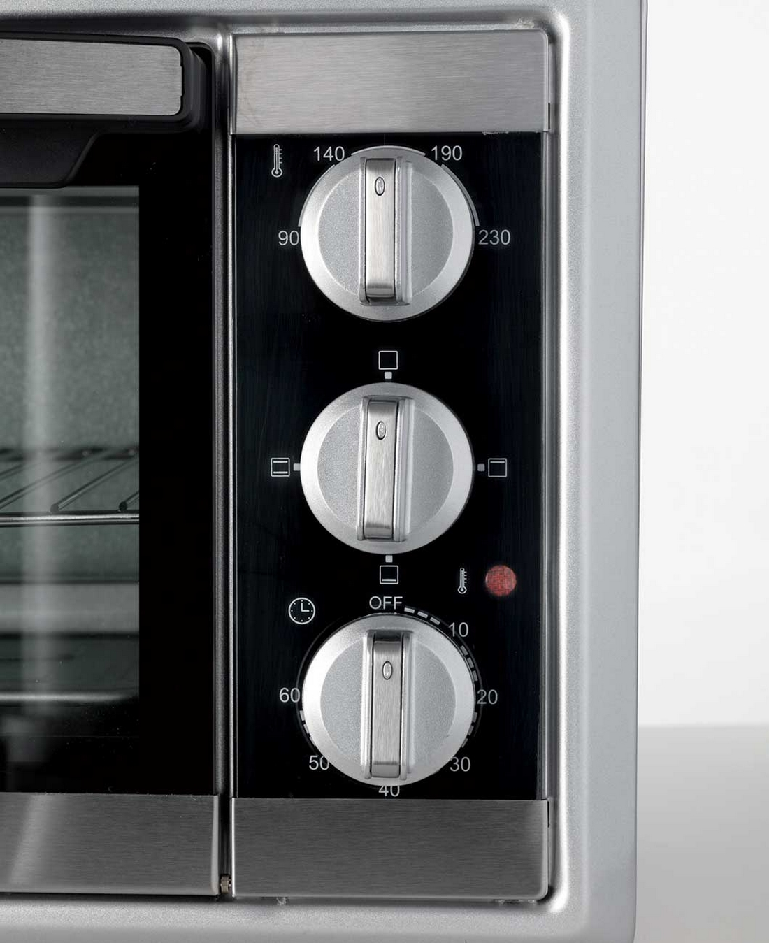 Panel sterowania piekarnika z trzema pokrętłami, ustawieniami temperatury i czasu oraz czerwoną lampką.