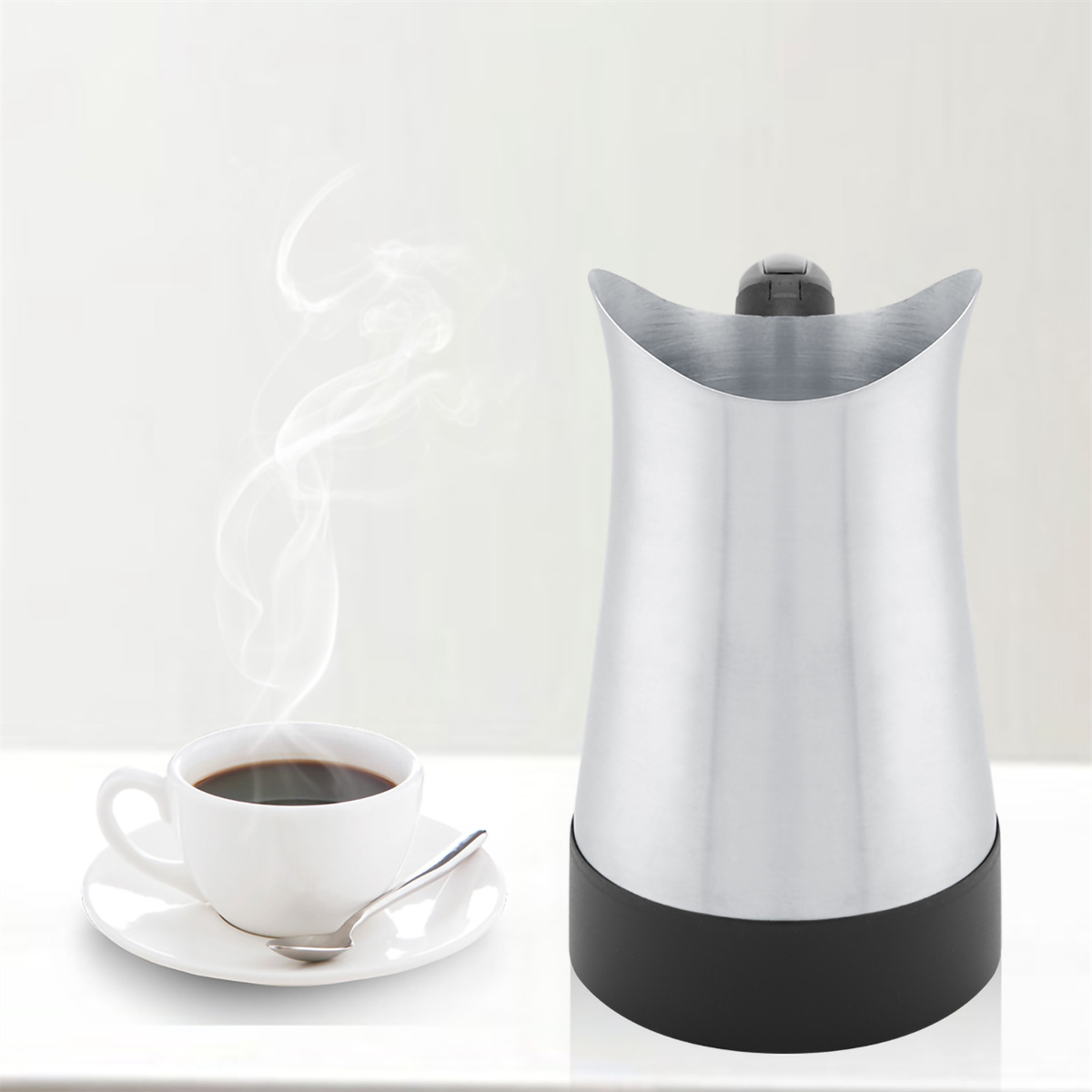 Kaffee mit aufsteigendem Dampf und ein silberner, schwarzbasierter elektrischer Kaffeebereiter. Weißer Hintergrund.
