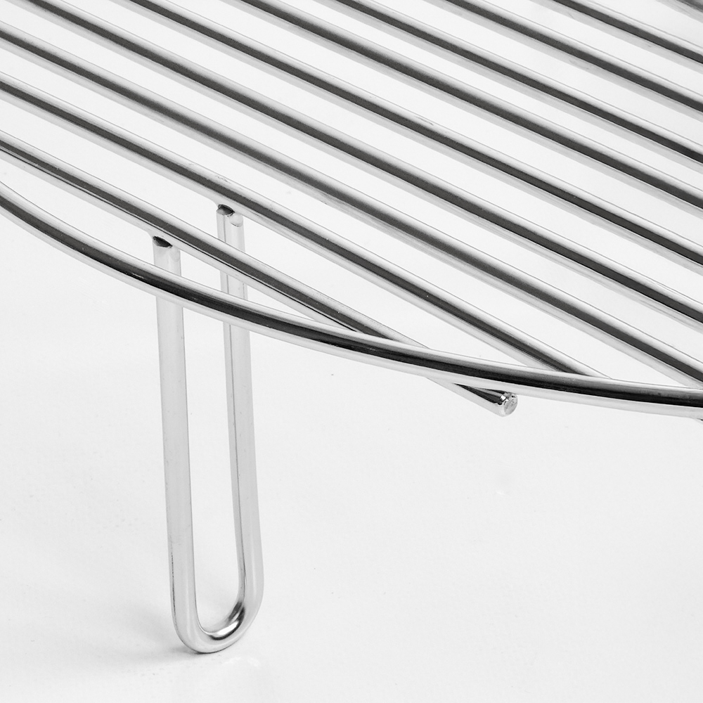 Chrome metal grill with U-shaped legs. The grill has horizontal bars and sits on a white surface.