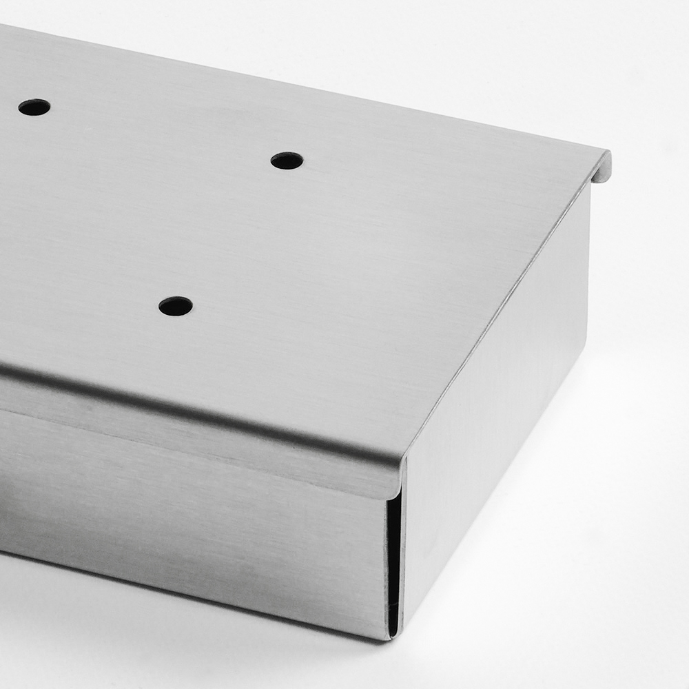 A stainless steel box with three holes on the top, shown on a white surface.