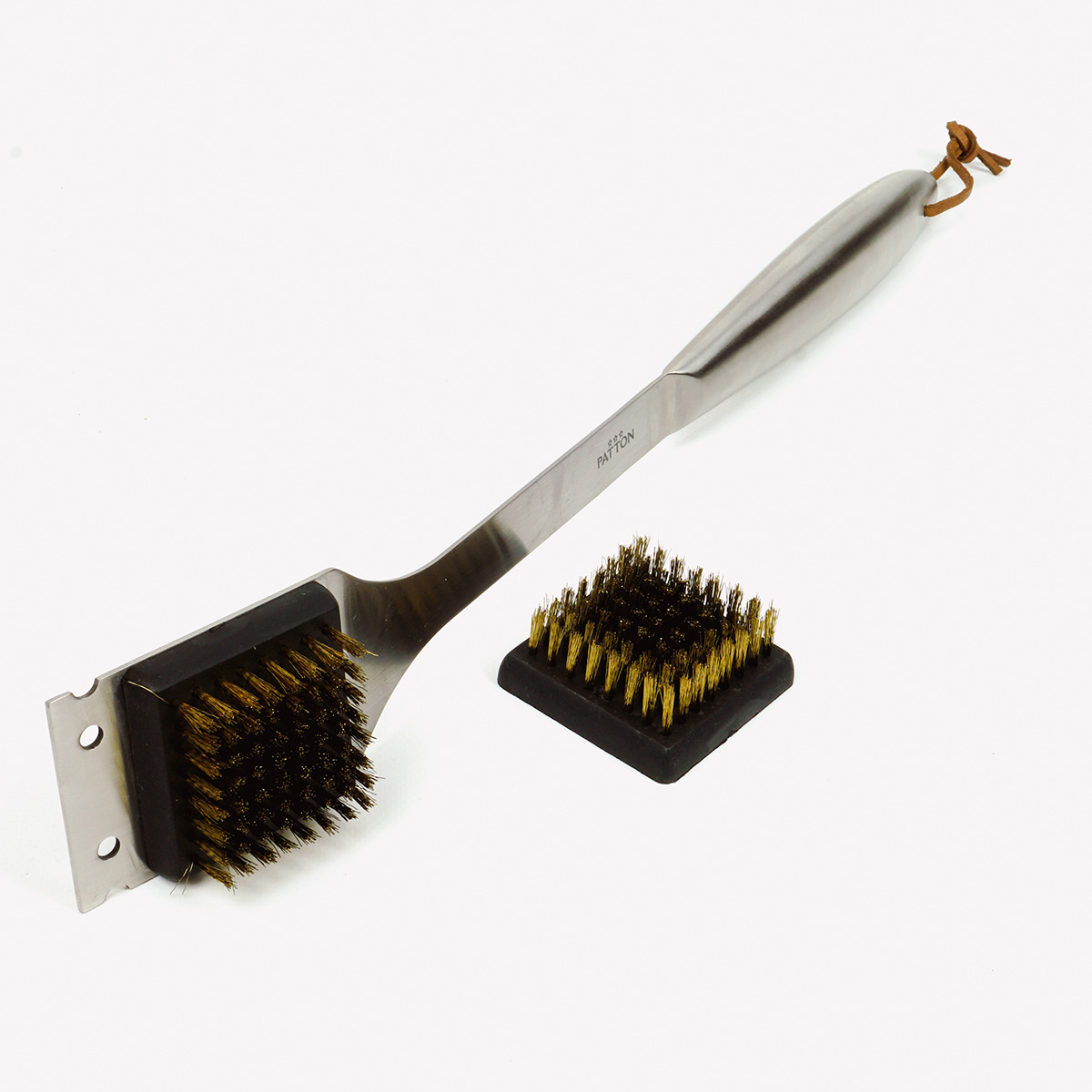 A stainless steel grill brush with a small scraper and a separate cleaning block.