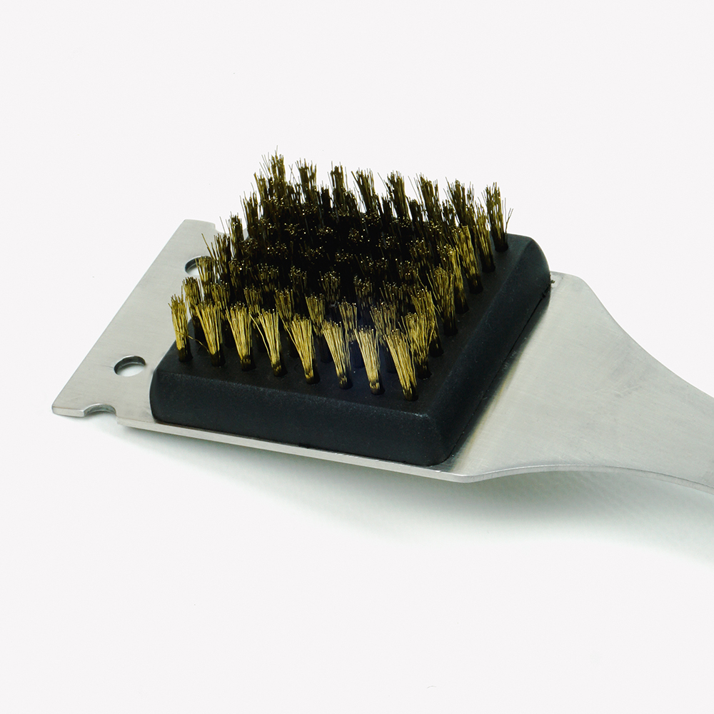 Barbecue grill brush with brass bristles and a metal scraper.