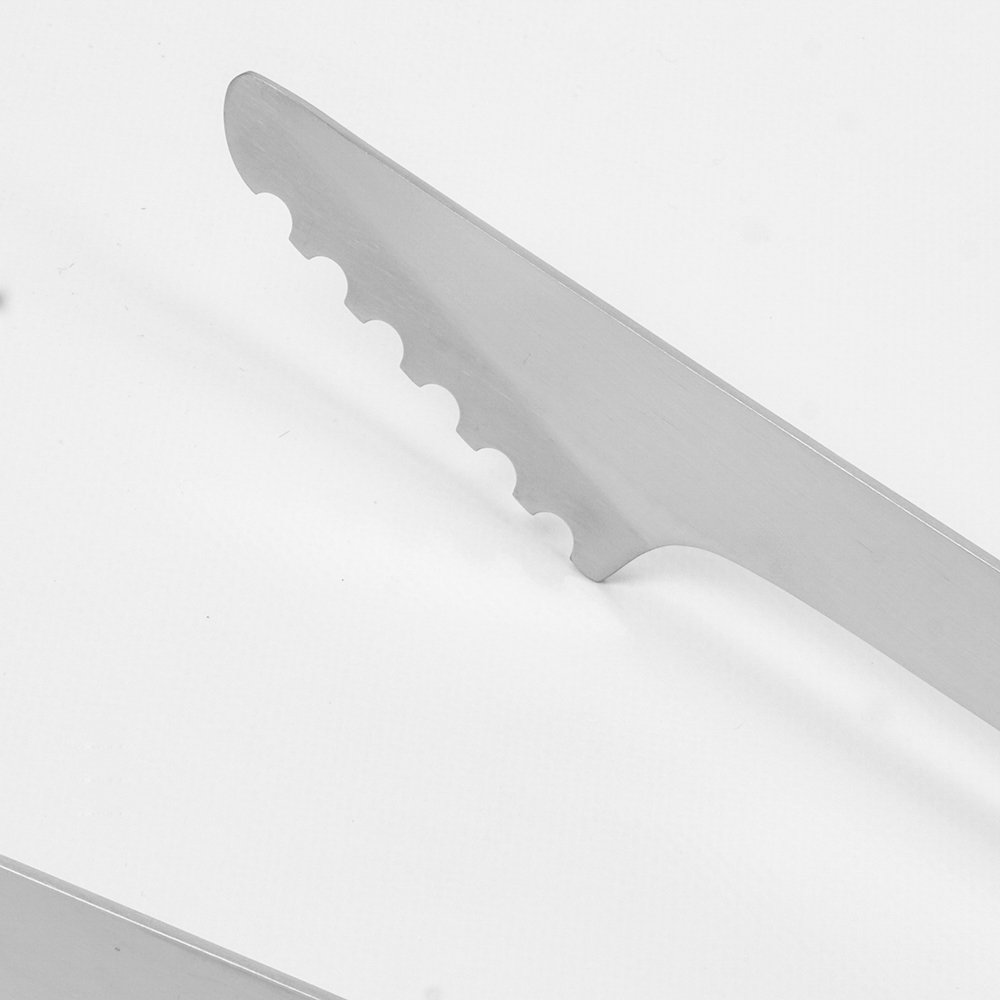 A close-up of a metal kitchen tong with a serrated edge.