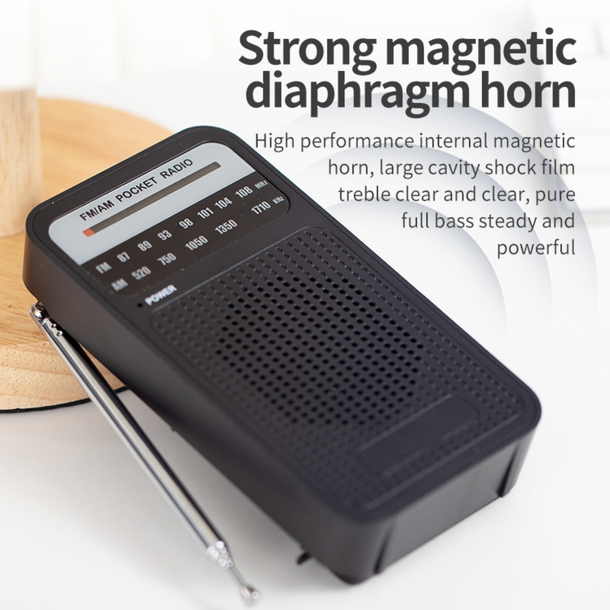 Ein schwarzes Taschenradio mit UKW/MW-Skala und einer silbernen Antenne auf weißem Untergrund.