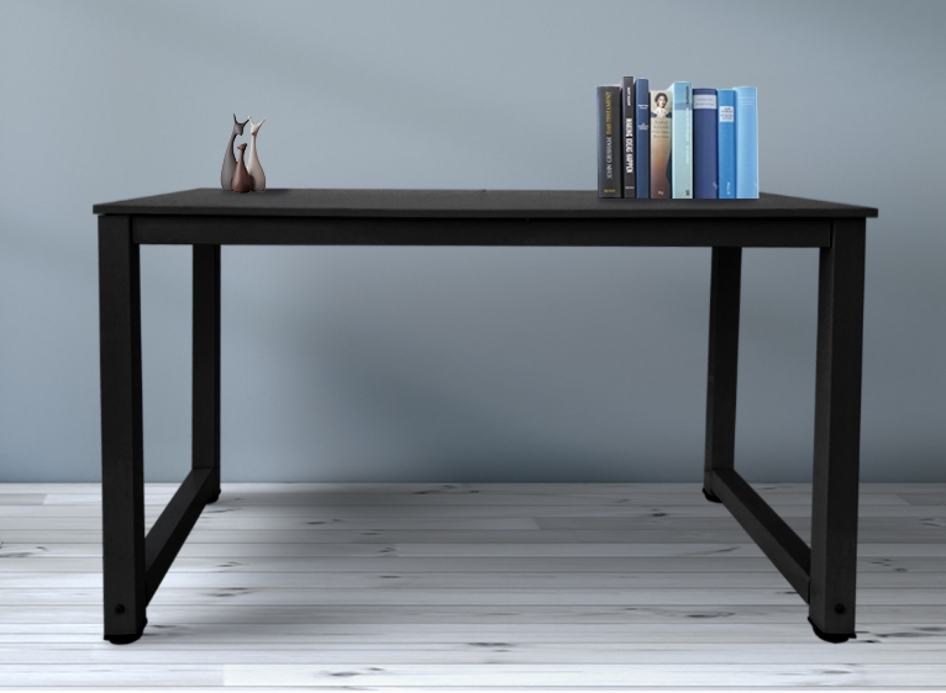 Een zwarte tafel met een houten blad en metalen poten, met boeken en een decoratieve figuur erop.