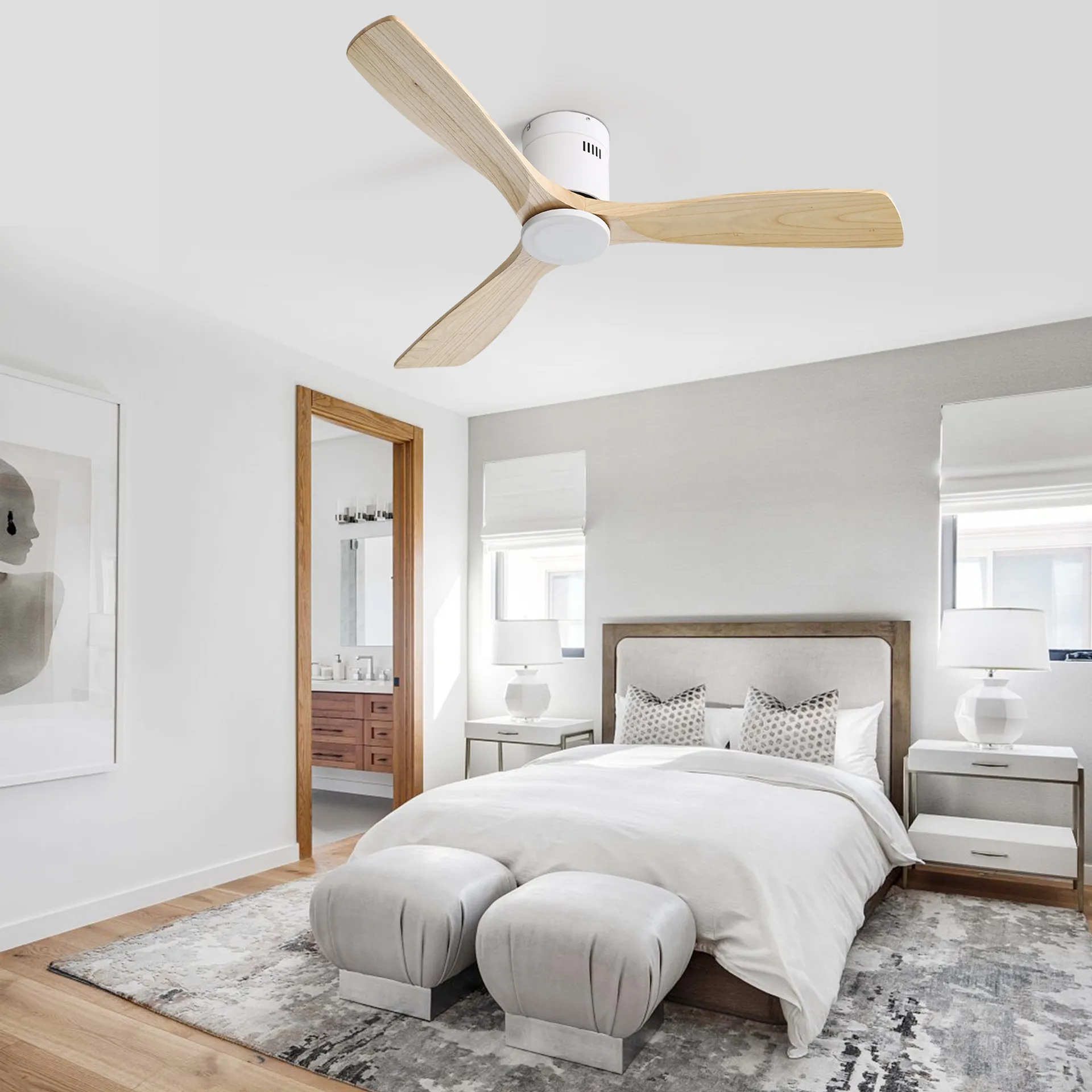 Schlafzimmer mit weißem Deckenventilator, Bett mit Kissen und zwei Ottomanen.