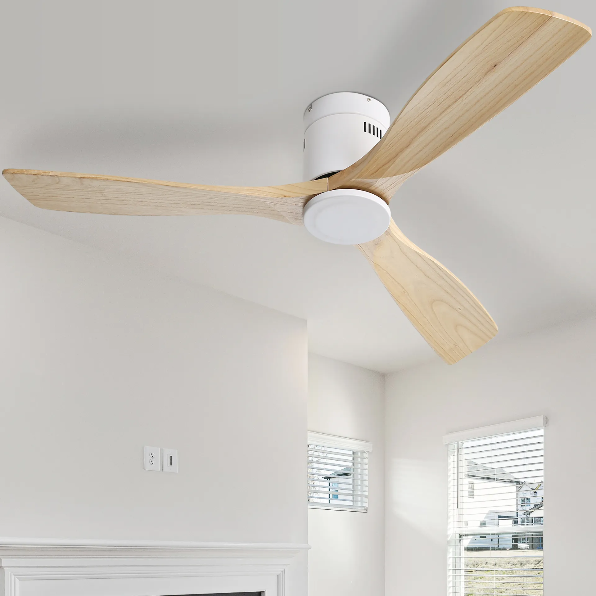 Deckenventilator mit drei Holzflügeln, weißem Motorgehäuse und weißer Decke, heller Raum.