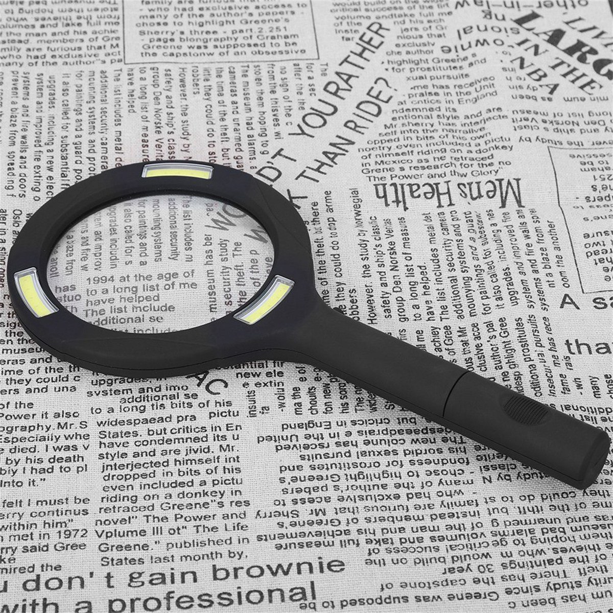 Eine Lupe über einer Zeitung. Das Glas hat ein Licht und einen schwarzen Griff.