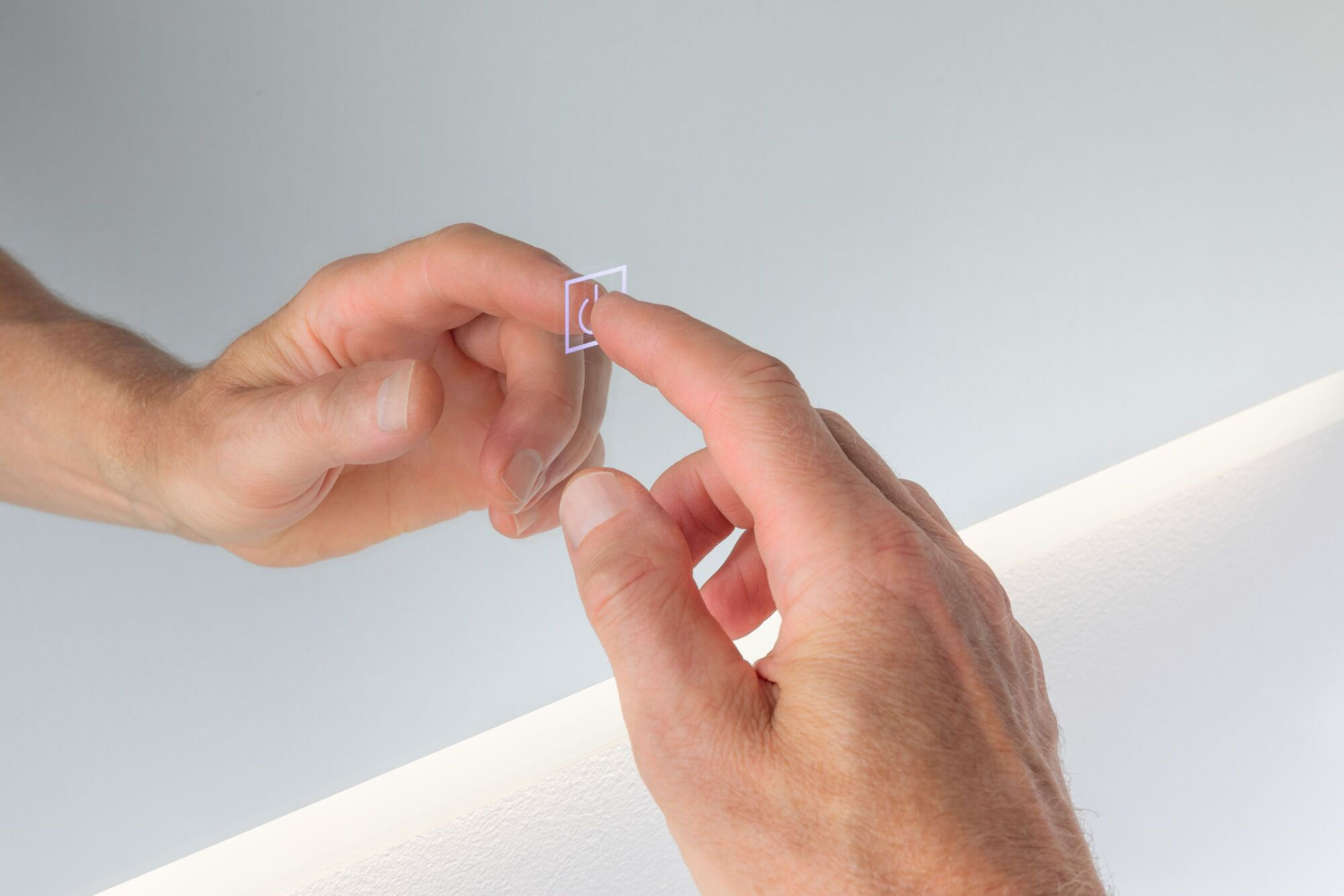 Hände berühren eine spiegelähnliche Oberfläche, ein Finger berührt ein quadratisches Symbol. Weißer Hintergrund.