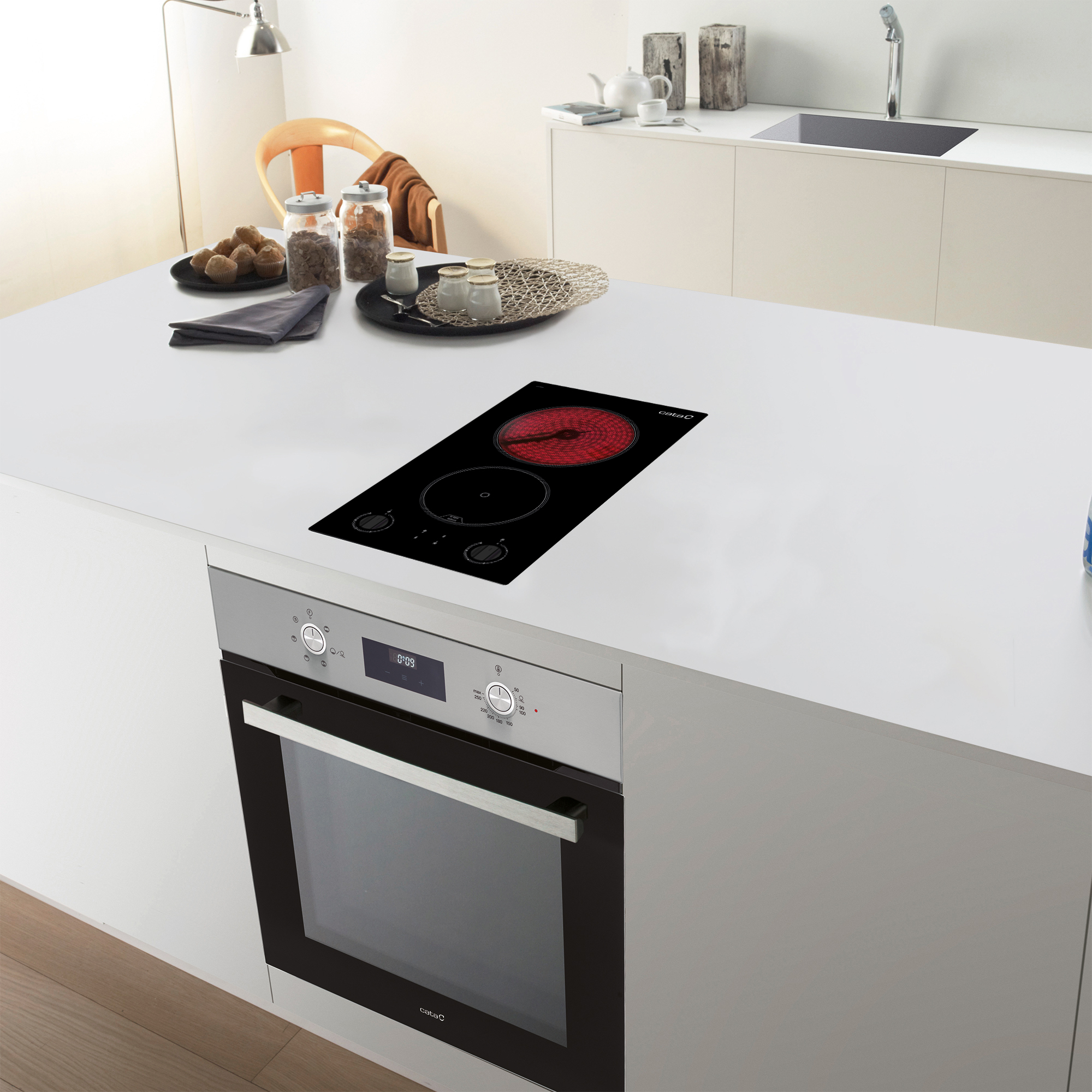 Isla de cocina con placa de cocina y horno. Un quemador rojo, dos negros.