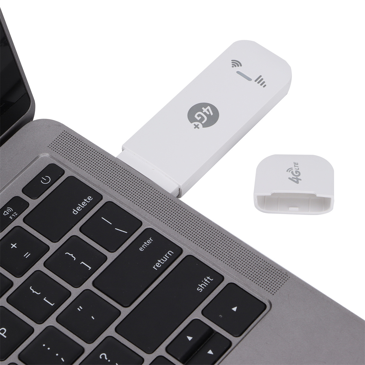 Weißes 4G-LTE-Modem, das an einen Laptop angeschlossen ist. Eine Hülle liegt daneben.