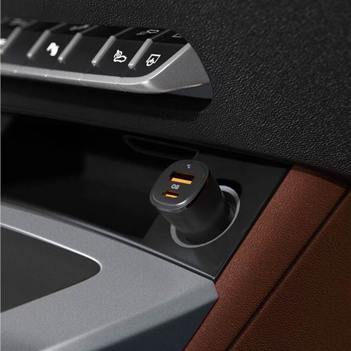 A black car charger with two USB ports. It's inserted into a car's power outlet.