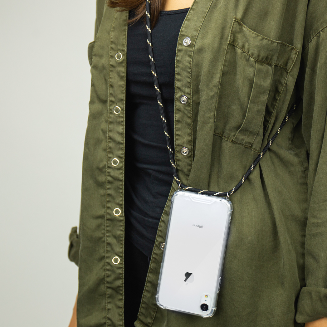 Téléphone dans une coque transparente avec cordon noir, contre une chemise verte.