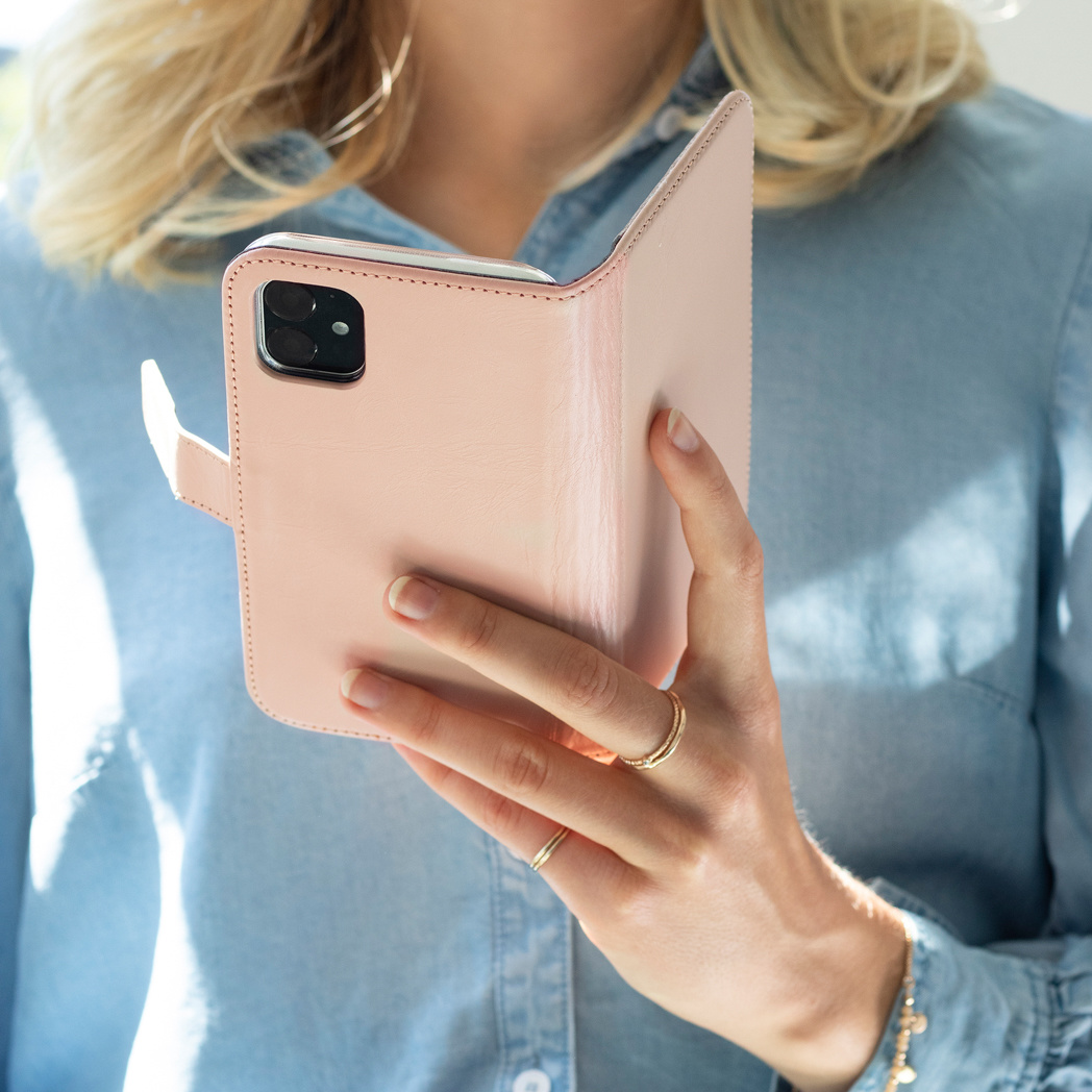 Eine Person hält eine rosa Handyhülle. Das Telefon ist in der Hülle.
