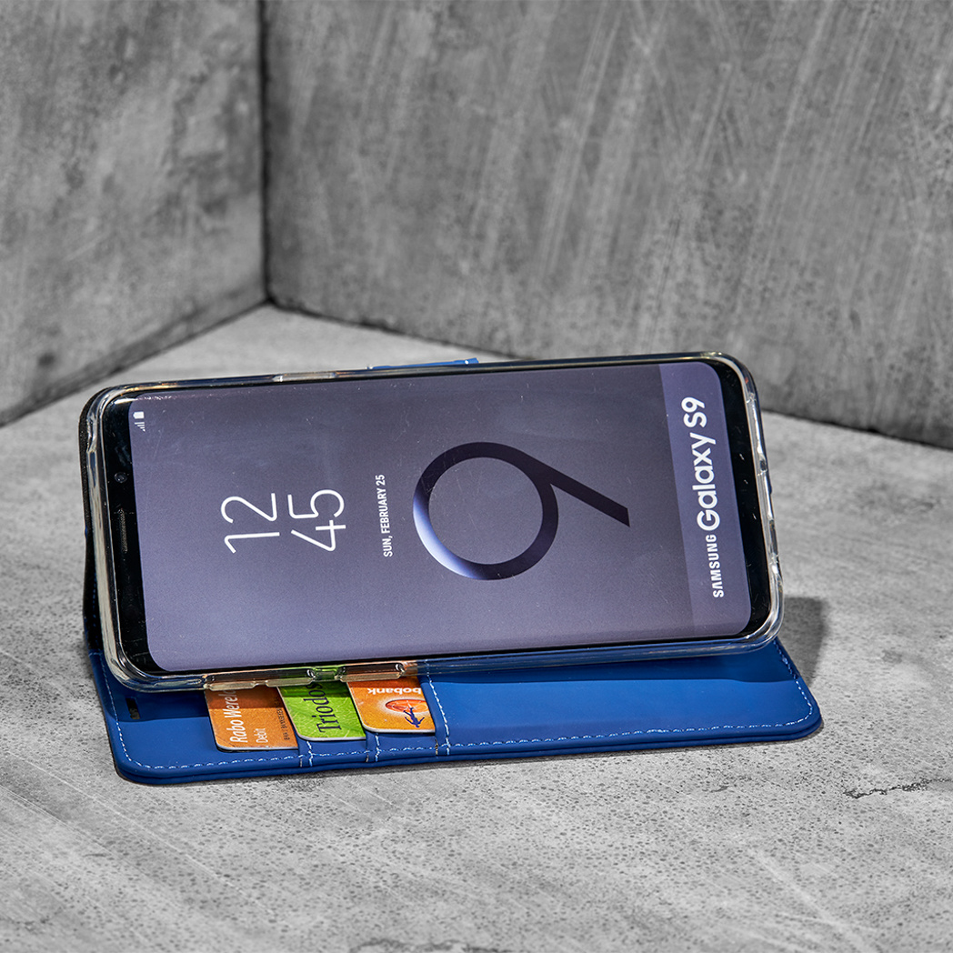 Een blauwe telefoonhoes met creditcards, met een Samsung Galaxy S9.