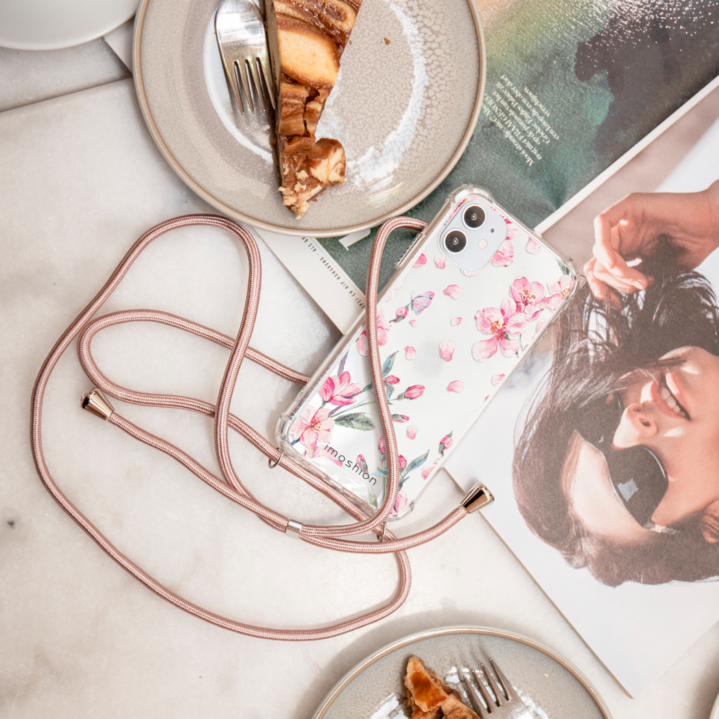 Overzichtsfoto met telefoonhoesje met bloemdesign en riem. Taart en tijdschrift zichtbaar.