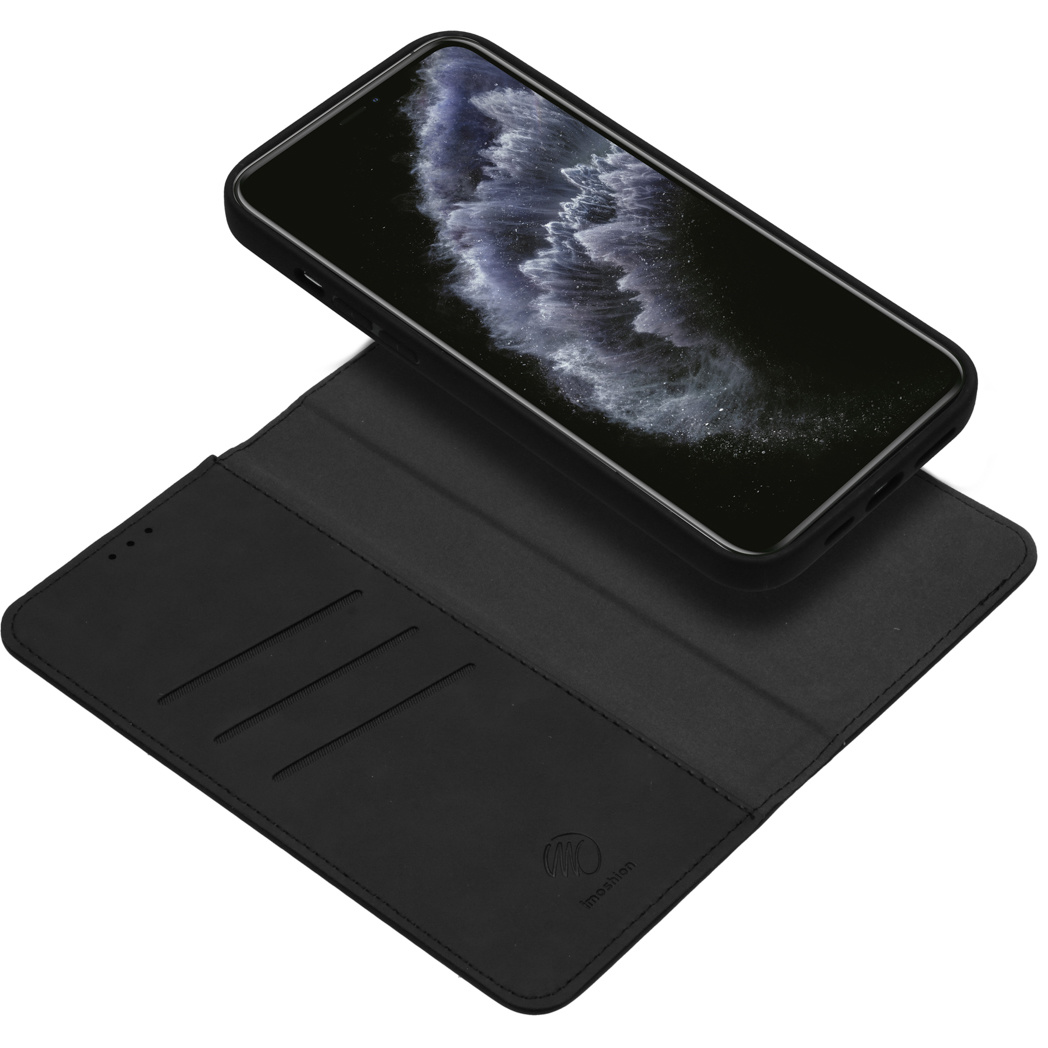 Téléphone noir sur un étui portefeuille noir. L'écran affiche une image sombre.