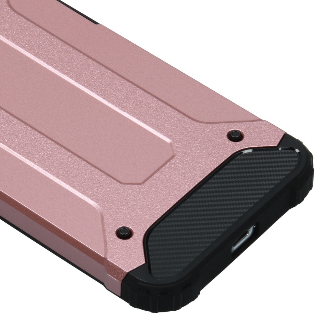 Een hoek van een roségouden telefoonhoesje met zwarte accenten, met een getextureerd oppervlak.