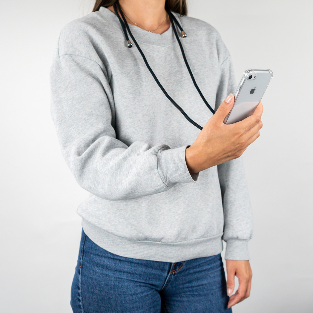 Persoon die een telefoon vasthoudt met een koord, draagt een grijze trui.