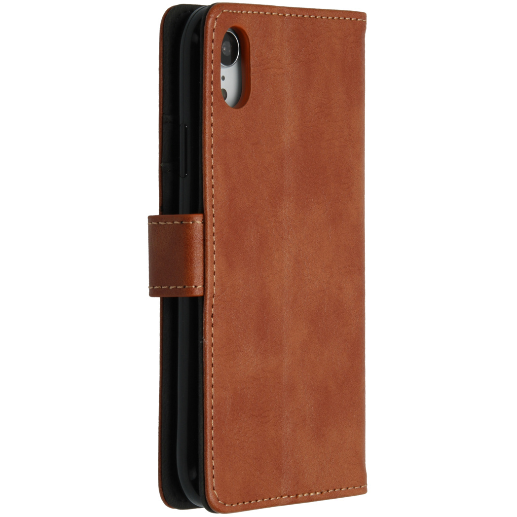 Un étui de téléphone en cuir marron, fermé, avec un téléphone à l'intérieur. Le téléphone a deux caméras.