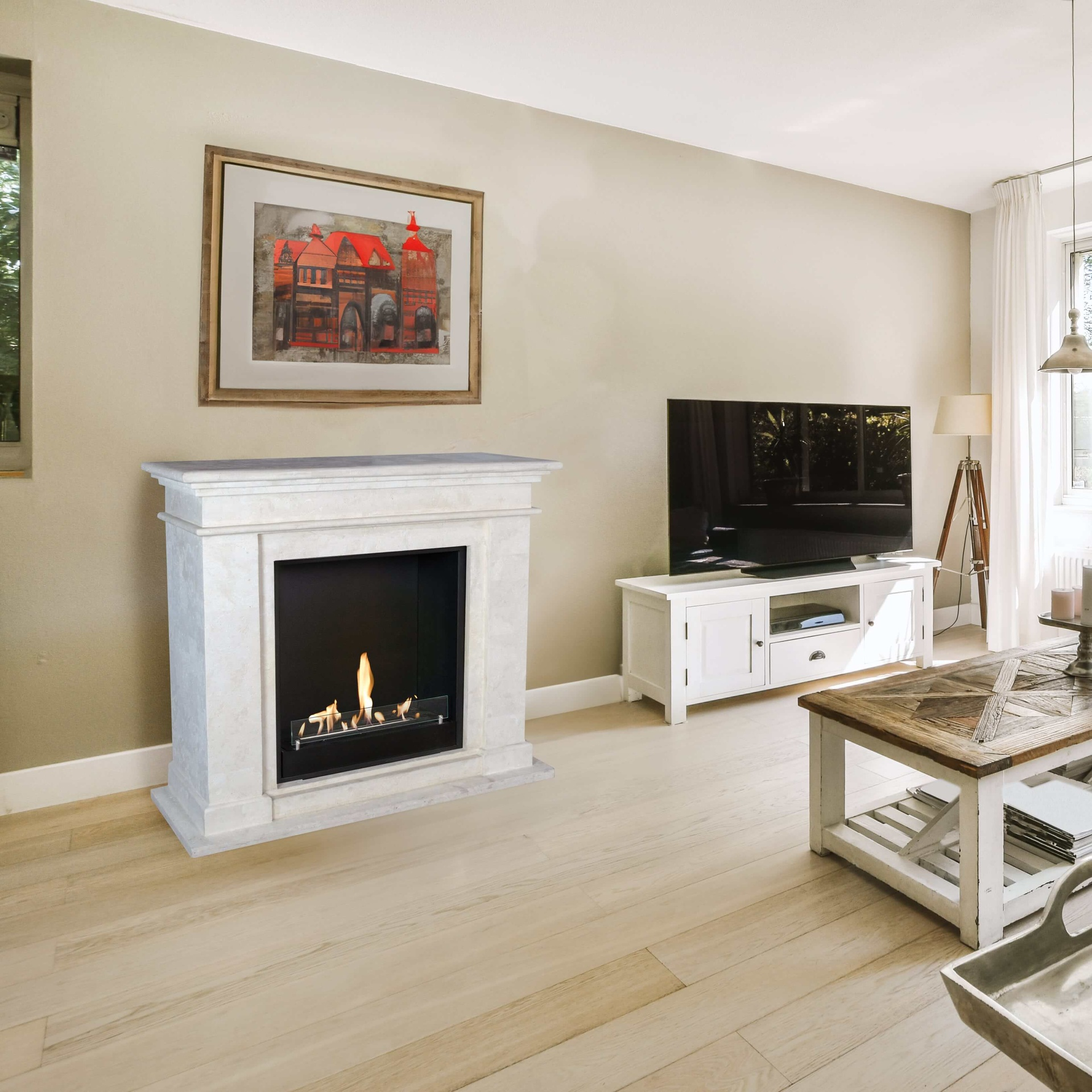 Een woonkamer met witte open haard met vlammen, tv, kunst en houten salontafel op houten vloer.