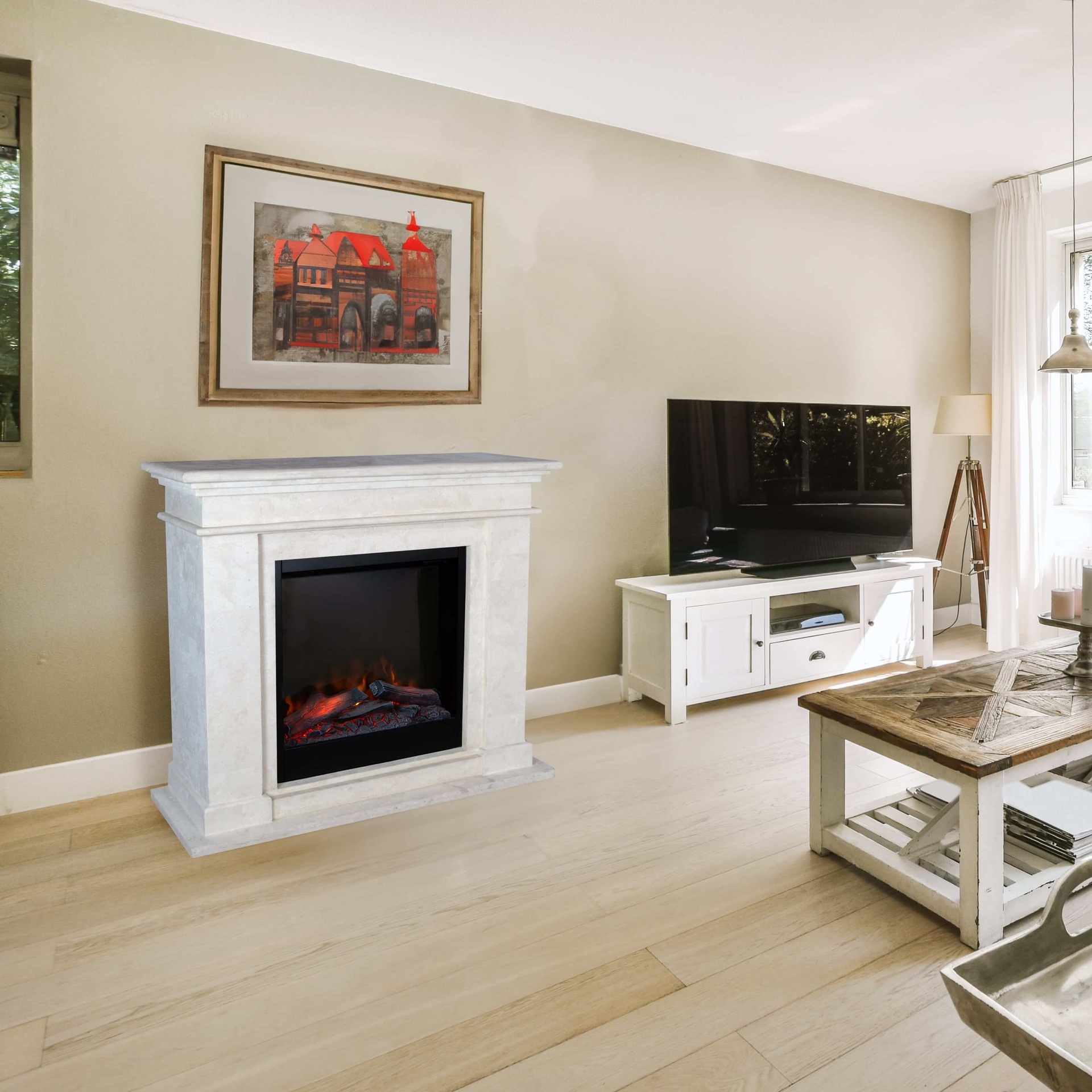 A living room with a fireplace, TV, and artwork. A coffee table and a lamp are also present. Light wood floor.