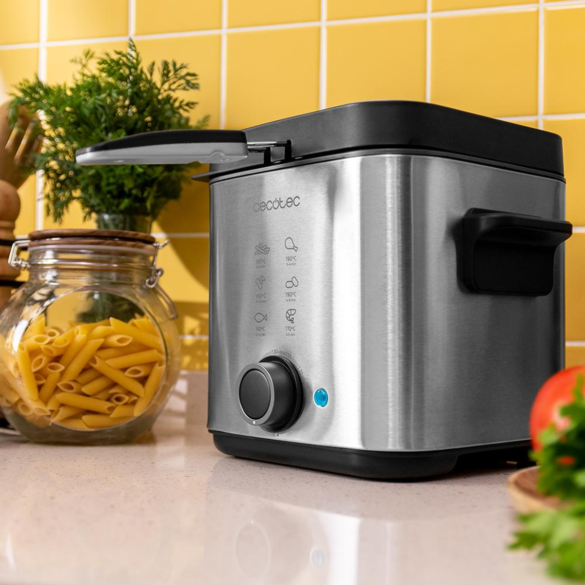 Frytownica ze stali nierdzewnej ze słoikiem makaronu i roślinami na blacie.