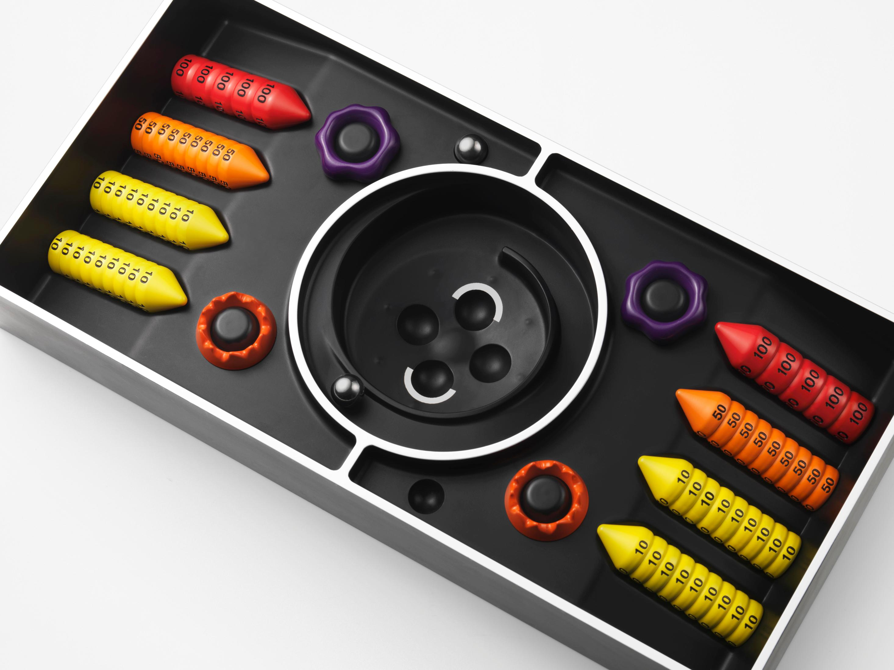 Un jeu noir avec des pièces colorées et des billes. Le jeu a un design en spirale.