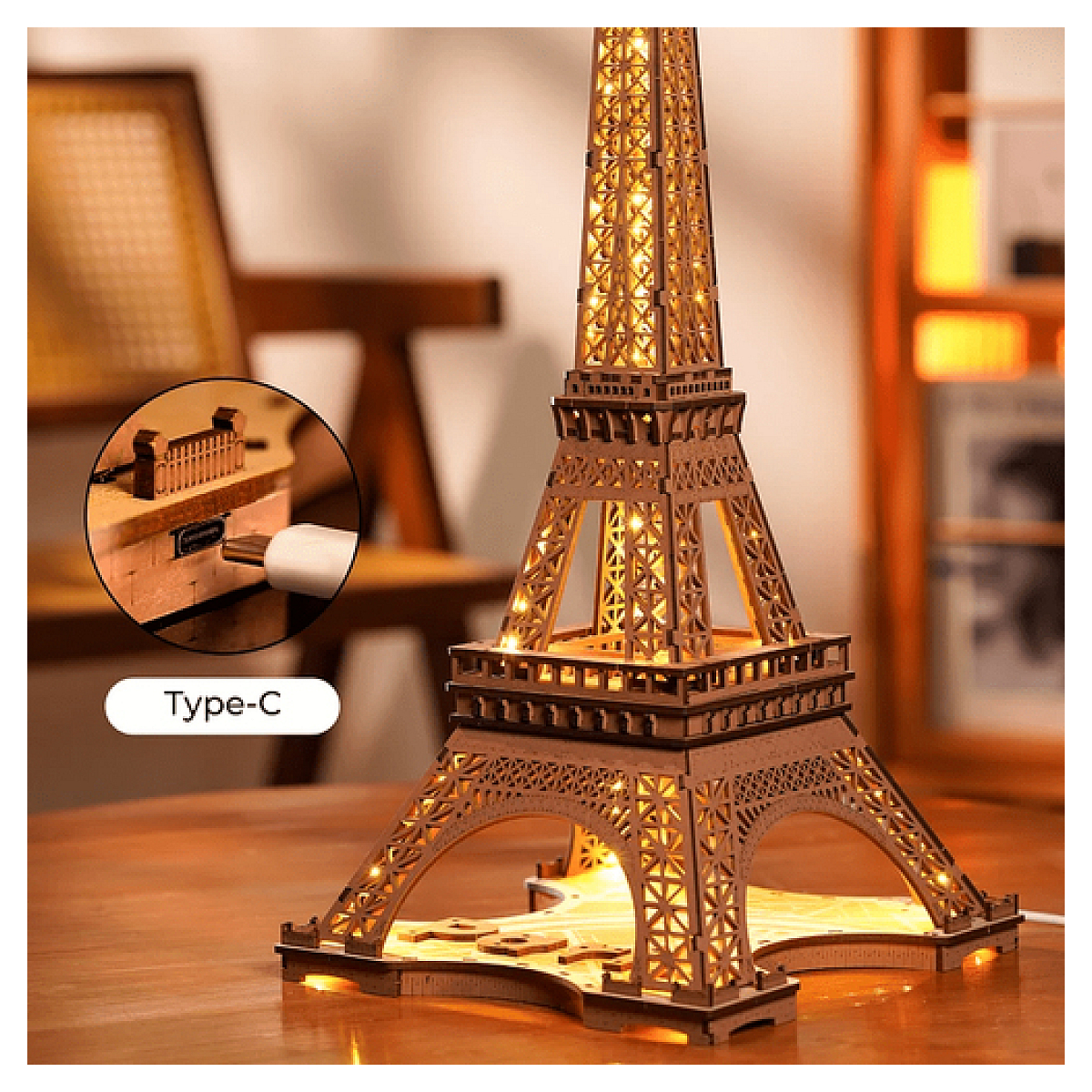 Podświetlana drewniana lampa w kształcie wieży Eiffla z kablem, obok portu ładowania typu C.