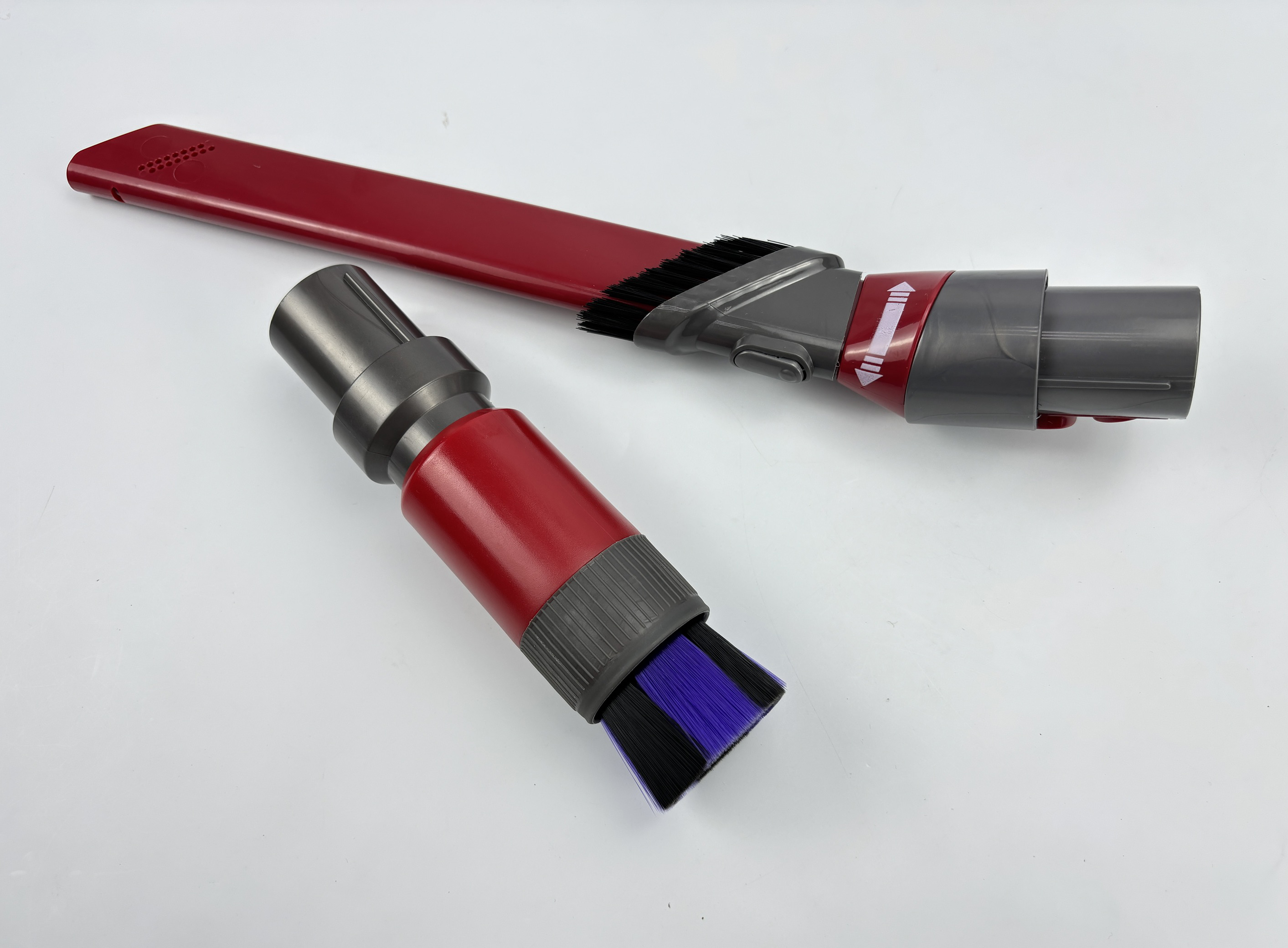 Końcówki do odkurzacza. Jedna jest czerwono-czarna ze szczotką. Druga jest czerwono-szara.