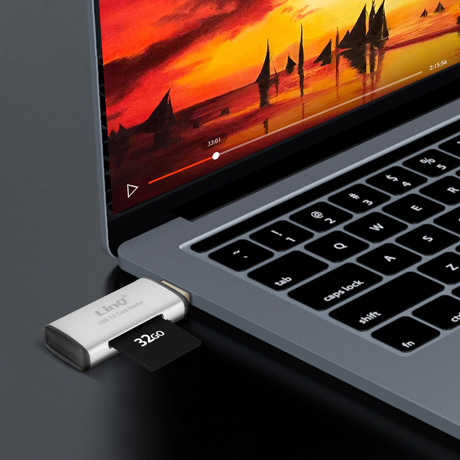 Lettore di schede USB argentato inserito in un laptop. Una scheda nera da 32 GB è nel lettore. Un video è in riproduzione.