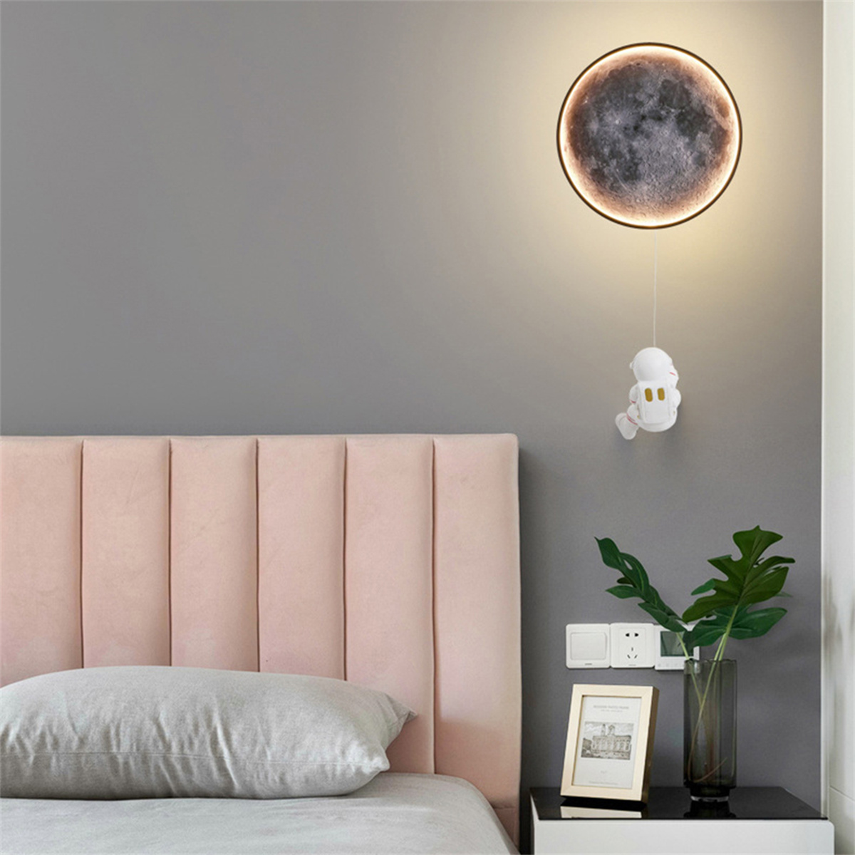 Ein Schlafzimmer mit einem Wandmondlicht und einer Cartoon-Astronautenfigur. Der Hintergrund ist grau.