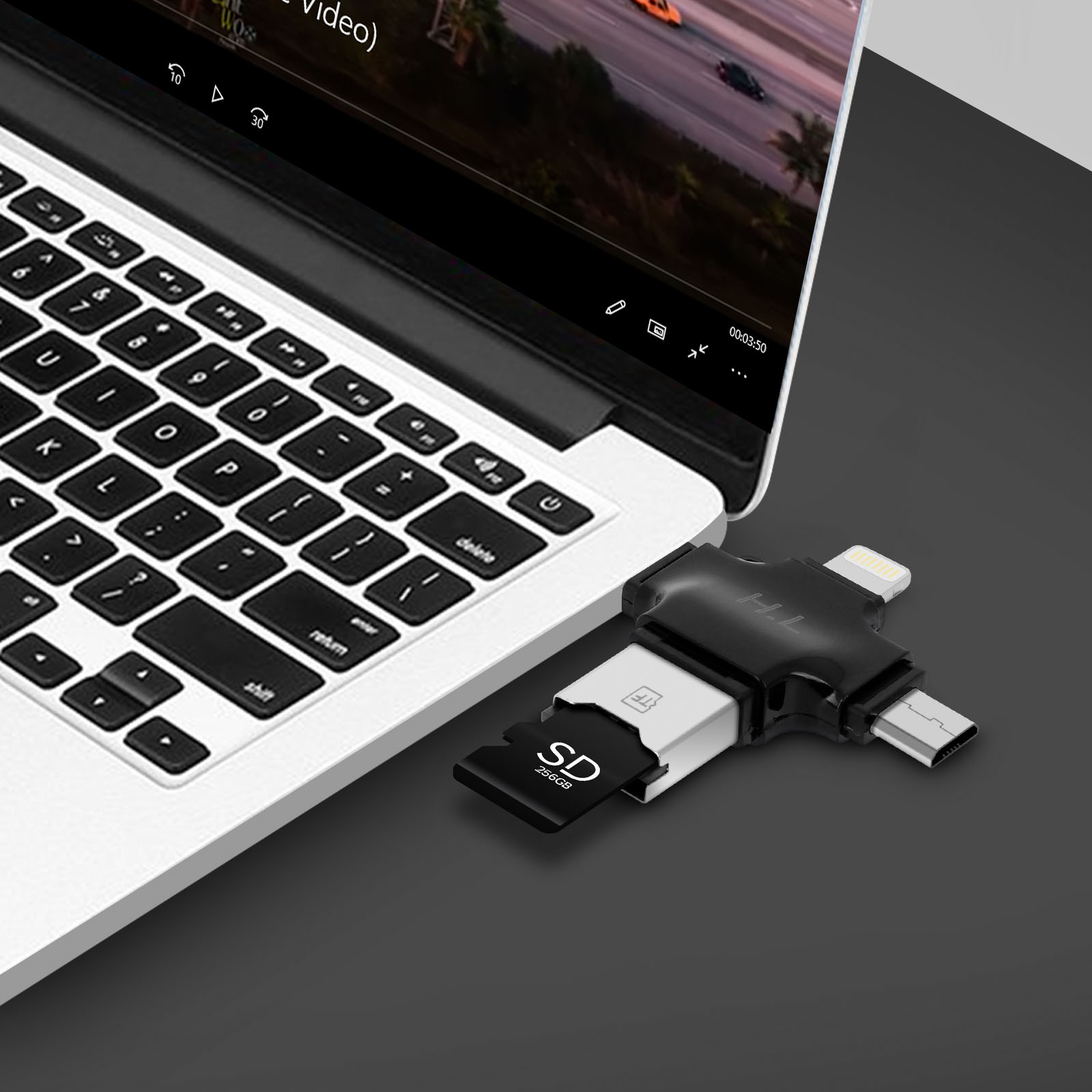 Un laptop con un adattatore USB collegato. Una scheda SD è inserita e un video è in riproduzione.