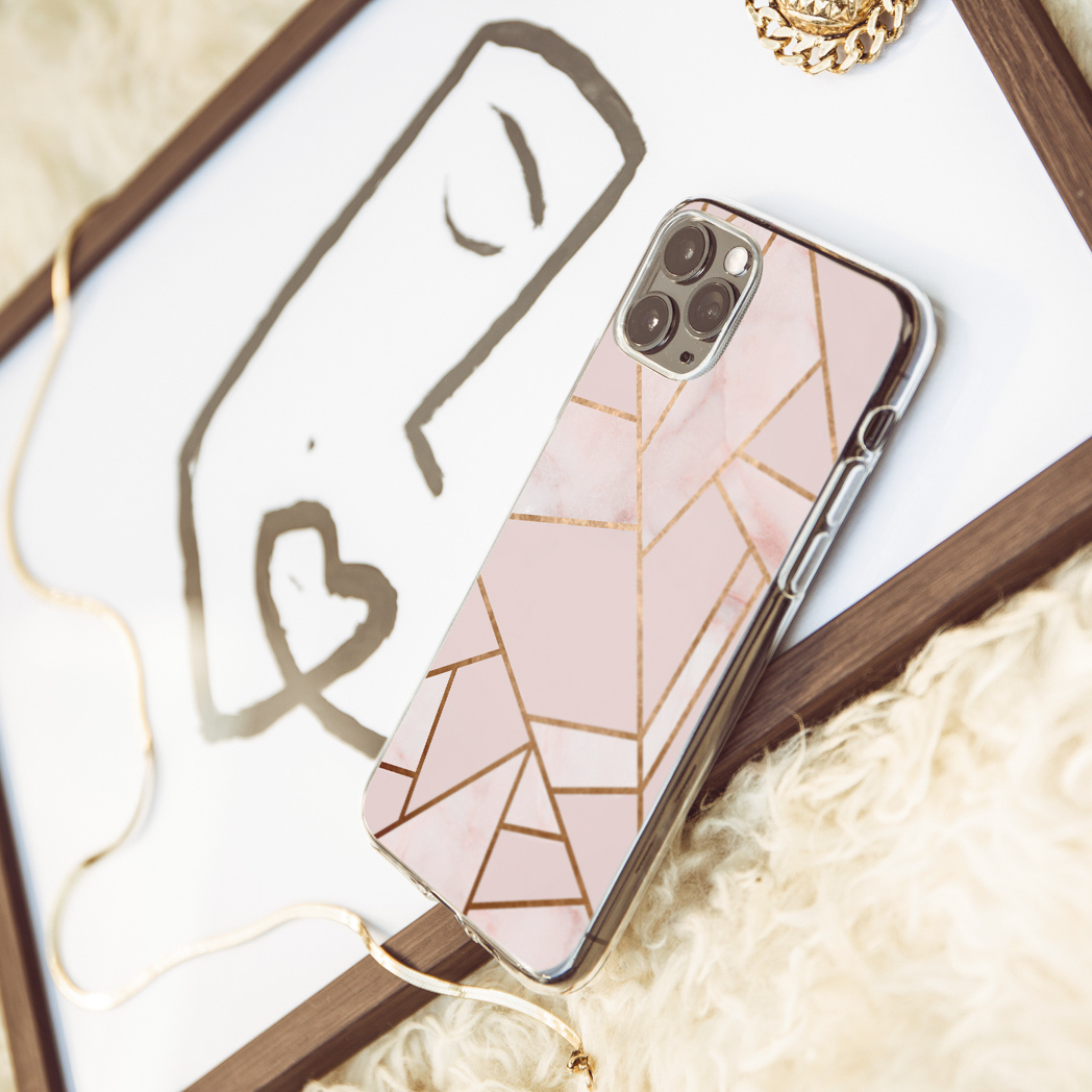 Een telefoon in een hoesje met een roze en gouden geometrisch ontwerp.